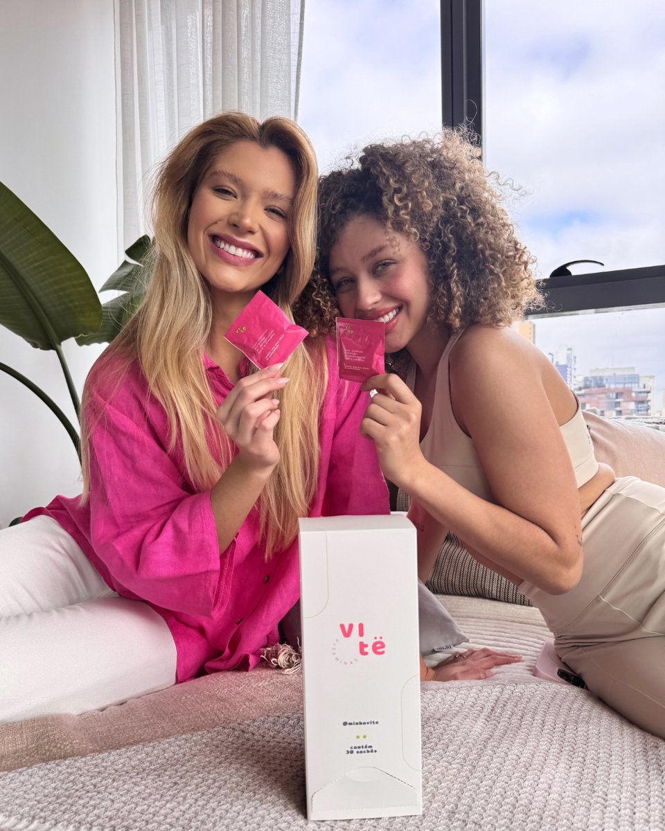 duas amigas sorrindo juntas segurando sachês da vitê